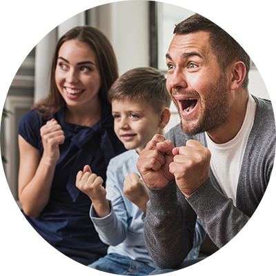 Family cheering while watching TV on the couch